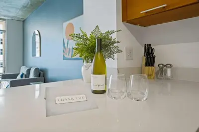a bottle of wine and two glasses on a counter at Urban Retreat - Location Pool Gym & Parking in Miami