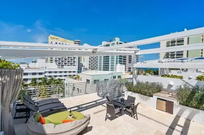 a balcony with chairs and tables on a building at Penthouse Bahia Mar South Beach on Ocean Drive Miami Beach home in Miami Beach