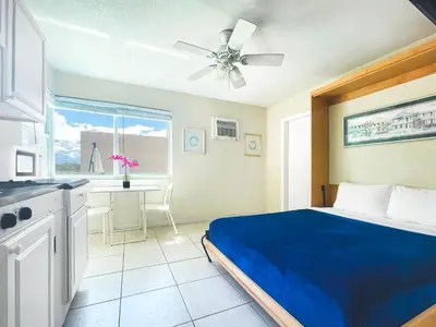 a bedroom with a blue bed and a kitchen at The Starfish in Hollywood