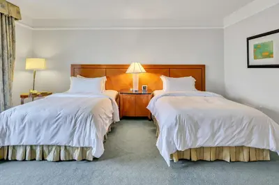 a hotel room with two beds with white sheets at Amazing private studio in Four Seasons Residences Brickell! in Miami