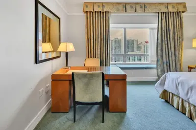 a hotel room with a desk and a bed and a window at Amazing private studio in Four Seasons Residences Brickell! in Miami