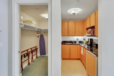 a small kitchen with wooden cabinets and a hallway at Amazing private studio in Four Seasons Residences Brickell! in Miami