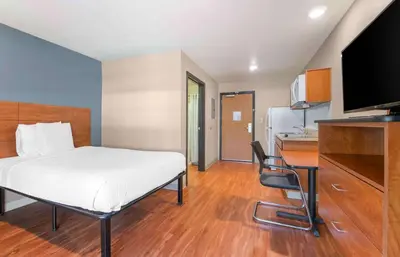 a bedroom with a bed and a desk and a kitchen at Extended Stay America Select Suites - Fort Lauderdale - Airport - West in Davie