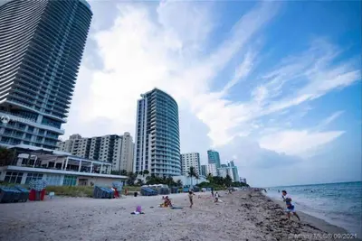 a group of people on a beach with buildings at Beachfront Apartment in Miami Beach with Stunning Views 1A in Hallandale Beach