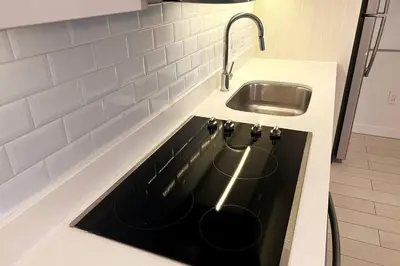a kitchen counter with a stove top with a sink at Beachfront Apartment in Miami Beach with Stunning Views 1A in Hallandale Beach