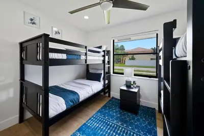 a bedroom with bunk beds and a blue rug at Villa Paradise Miami, Luxury Gem with Heated Pool, Game Room, Fire Pit, 3 Bed 2 Bath in Miami