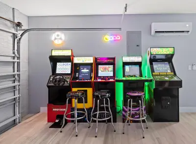 a room with four video game machines and stools at Villa Paradise Miami, Luxury Gem with Heated Pool, Game Room, Fire Pit, 3 Bed 2 Bath in Miami
