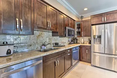 a kitchen with wooden cabinets and stainless steel appliances at Spacious Miami Retreat with Grill, Pool and Dock! in Miami