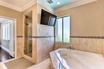 a large bathroom with a tub and a tv at Spacious Miami Retreat with Grill, Pool and Dock! in Miami