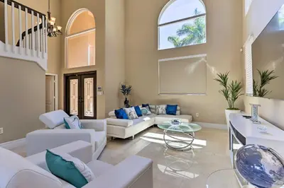 a living room with white furniture and a staircase at Spacious Miami Retreat with Grill, Pool and Dock! in Miami