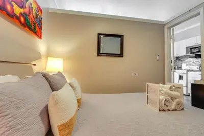 a bedroom with a large bed and a mirror at Sunny Miami Beach Condo Steps to Boardwalk! in Miami Beach