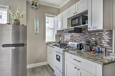 a kitchen with white cabinets and a stainless steel refrigerator at Sunny Miami Beach Condo Steps to Boardwalk! in Miami Beach