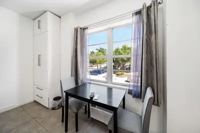a dining room with a table and a window at Beach Bae -Deco Studio Steps from the Ocean in Miami Beach