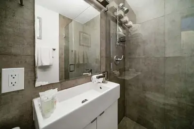 a bathroom with a white sink and a mirror at Beach Bae -Deco Studio Steps from the Ocean in Miami Beach
