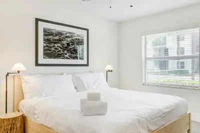 a white bedroom with a large bed with white pillows at Tucker at Palm Trace Landings Fort Lauderdale in Davie