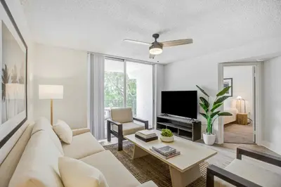 a living room with a white couch and a tv at Tucker at Palm Trace Landings Fort Lauderdale in Davie