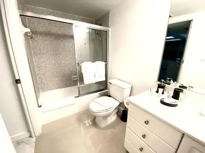 a white bathroom with a toilet and a shower at Zen Vacation Rentals Modern Penthouse Across Ocean in Miami Beach