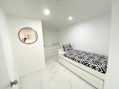a white room with a bed and a mirror at Zen Vacation Rentals Modern Penthouse Across Ocean in Miami Beach