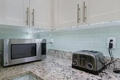 a microwave sitting on a counter in a kitchen at Heated Pool I Soundproof Home I Firepit I 630Mbps in Hollywood