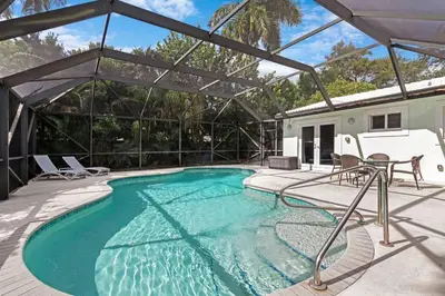 a swimming pool with chairs and a table on a patio at Heated Pool I Soundproof Home I Firepit I 630Mbps in Hollywood