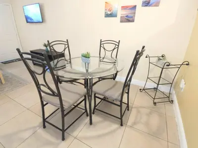 a glass table and four chairs in a room at Chic 2BR Little Havana Apt with Free Parking in Miami