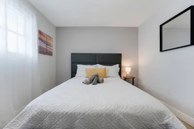 a teddy bear sitting on a bed in a bedroom at Chic 2BR Little Havana Apt with Free Parking in Miami