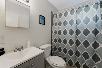 a bathroom with a toilet and a sink and a mirror at Chic 2BR Little Havana Apt with Free Parking in Miami