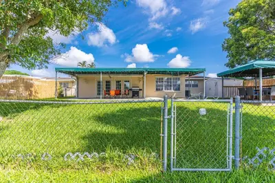 a chain link fence in front of a house at Private Lakefront Home in Miami/Pembroke in Pembroke Pines