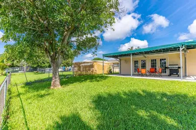 a house with a tree in the yard at Private Lakefront Home in Miami/Pembroke in Pembroke Pines