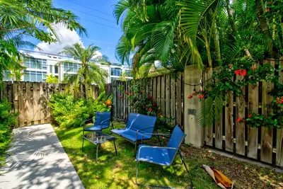 a backyard with blue chairs and a fence at Efficiency 3 on water Las Olas beach and free kayaks in Fort Lauderdale