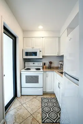a white kitchen with a stove and a microwave at A 1bedroom Las Olas on the water in Fort Lauderdale