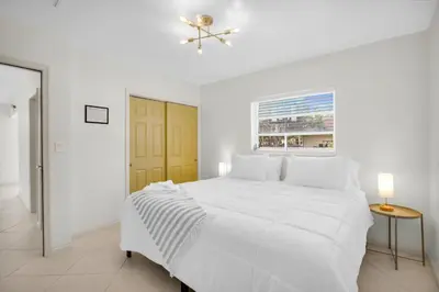 a white bedroom with a white bed and a window at LoKal Rental Tropical Florida destination in Fort Lauderdale