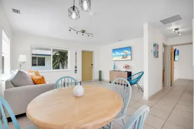 a dining room and living room with a wooden table and chairs at LoKal Rental Tropical Florida destination in Fort Lauderdale