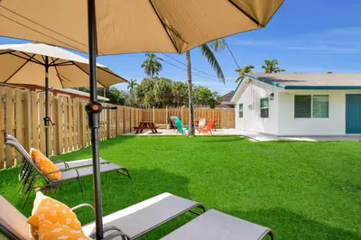 a yard with two chairs and an umbrella at LoKal Rental Tropical Florida destination in Fort Lauderdale