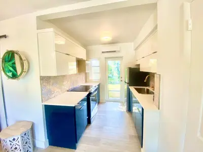 a kitchen with white cabinets and blue counters at 3 Seasons at the Carrington 3 Two Bedroom 1 Bath Apts -6 Bedrooms 3 bathrooms and 3 bedroom 2 bathroom Villa in Miami
