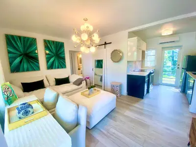 a living room with a white couch and a chandelier at 3 Seasons at the Carrington 3 Two Bedroom 1 Bath Apts -6 Bedrooms 3 bathrooms and 3 bedroom 2 bathroom Villa in Miami