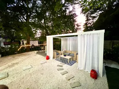 a gazebo with a couch and chairs in the sand at 3 Seasons at the Carrington 3 Two Bedroom 1 Bath Apts -6 Bedrooms 3 bathrooms and 3 bedroom 2 bathroom Villa in Miami