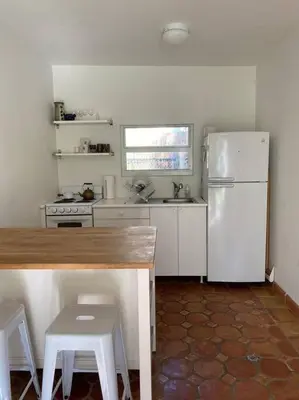 a kitchen with a refrigerator and a table and chairs at Miami guest house with large pool in Miami