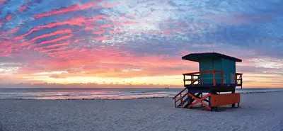 a lifeguard tower on the beach at sunset at 1BR Little Havana Apt stepts to Calle 8 in Miami