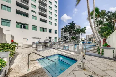a swimming pool in front of a building at Modern Ft Lauderdale Condo about 7 Mi to Airport! in Fort Lauderdale