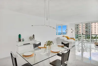 a white dining room with a glass table and chairs at Special Offer - Balcony - Beachfront Condo - Gym in Hollywood