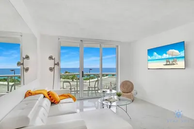 a living room with a white couch and a view of the ocean at Special Offer - Balcony - Beachfront Condo - Gym in Hollywood