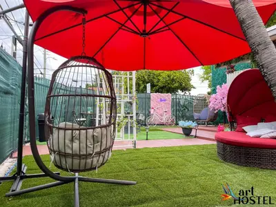 a red bird cage sitting under a red umbrella at Summer Gardens in Miami