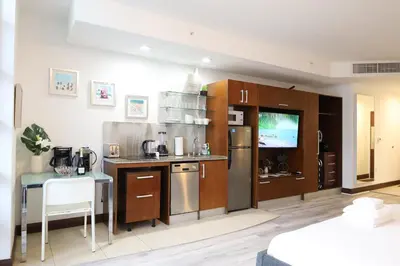 a kitchen with stainless steel appliances and a table at Rooftop-Pool Suite with King Bed in Ocean Dr C303 in Miami Beach
