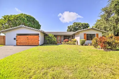 a house with a green lawn in front of it at Wilton Manors Home with Pool about 4 Mi to Beach! in Fort Lauderdale