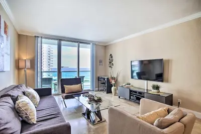 a living room with a couch and a tv at Ocean-View Balcony Beachfront Hollywood Apt! in Hollywood