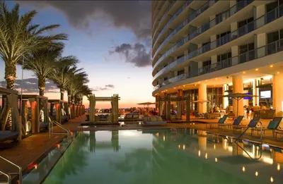 a hotel with a swimming pool in front of a building at Modern Beachfront Condo with Stunning Ocean View in Hollywood