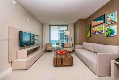 a living room with a couch and a tv at Modern Beachfront Condo with Stunning Ocean View in Hollywood