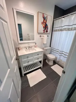 a bathroom with a sink and a toilet and a mirror at Luxe Fort Lauderdale in Fort Lauderdale
