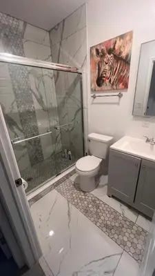 a bathroom with a shower and a toilet and a sink at Luxe Fort Lauderdale in Fort Lauderdale